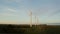 Horizontal panning from a drone, view of a massive wind farm among green fields