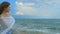 Horizontal panorama of beautiful lonely woman on sea shore, hair waving in wind