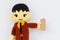 horizontal photo of closeup businessman doll knitting wool holding brown price tag on white wall background, copyspace