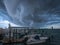 A horizontal photo of a huge storm cell shelf cloud over a bay in New Jersey in the summer.