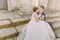 Horizontal photo of the newlyweds holdign hands while sitting on the stairs of the ancient building.