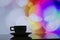 Horizontal photo of silhouette coffee cup on colorful bokeh back