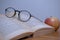 Horizontal photography in vintage style round glasses, red apple and old book