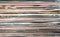 Horizontal pile of many close standing vinyl records covers as background front view closeup