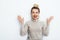 Horizontal portrait of cheerful woman with delight emotion, having hair bun wearing in sweater isolated over white background.