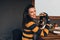 Horizontal portrait of hungry happy woman wearing casual sweater, eatting delicious burger while sitting at terrace. Female