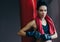 Horizontal portrait of strong attractive brunette woman with red towel on neck before workout with punch bag, wearing kickboxing