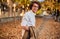 Horizontal potrait of young businessman with glasses posing outdoors going to the lunch. Male student in autumn street. Smart guy