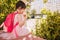 Horizontal rear view of beautiful little girl sitting and eating ice cream with blurred buildings outdoor. Happy kid girl relaxing