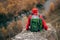 Horizontal rear view image of young handsome hiker man sitting on the rock, relaxing and enjoy the beautiful nature view.