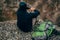 Horizontal rear view shot of young handsome hiker man sitting on the rock, relaxing and enjoy the beautiful nature view.