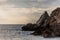 Horizontal seascape with cloudy sky, rocks and seagulls