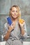 Horizontal shot of beauty woman with a wet hair holding packaging of shampoo with a piece of orange. Citrus extract for