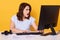 Horizontal shot of brunette woman using computer, reading shocking information on PC screen, posing with opened mouth isolated