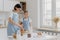 Horizontal shot of caring mother and daughter cook together, mom gives culinary lesson to small girl, use flour, eggs and milk to