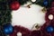 Horizontal shot of decorative snowballs and beads, gold presents, red and blue balls, green tinsel on white background. Top view