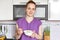 Horizontal shot of good looking young woman with no make up, dressed casually, holds white bowl with porridge, going to have break