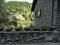 Horizontal shot of green plants in clay pots on a wall near a stone house in Rupit, Spain