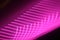 Horizontal shot of intersecting refracted pink light layers on a black background