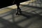 Horizontal shot of a male with his shadow walking on the road at nighttime