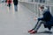 Horizontal shot of man holds modern mobile phone, being in mall during pandemic and coronavirus, wears protective medical mask,