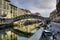 Horizontal shot of the Naviglio canal with a concrete bridge and colorful buildings in Milan, Italy