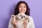 Horizontal shot of positive funny model with peaceful facial expression, raising Maltese paws, spending time with her favourite