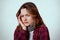 Horizontal shot of sickness young woman keeping hand on temple posing isolated over white studio background, having terrible