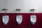 Horizontal shot of three urinals on a red and white wall