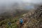 Horizontal shot of two hikers walking on a rocky mountain overlooking the lake at the top of Cerro Chirripo in Chirripo National