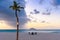 Horizontal shot of the view of the beach and sea, with palm trees, umbrella and chairs in Aruba