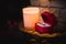 Horizontal shot wedding rings in a beautiful red box next to a candle