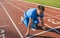 Horizontal shot of young athlete male at starting position ready to start a race. Man sprinter ready for sports exercise on