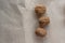 Horizontal. Three inshell walnuts on old peppermint kraft paper, brown background, warm beige pattern