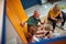 Horizontal top shot of people in gym locker room talking, senior man explaining something to others