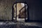 Horizontal view of an abandoned building with an arch and a staircase behind it