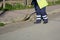Horizontal View of a Dustman Working in the Street Using a Wooden Mop and Dressing a Yellow Jacket