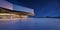 Horizontal view of empty cement floor with steel and glass modern building exterior