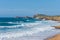 Horizontal view of Liencres beach on a sunny summer afternoon with waves, in Cantabria