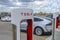 A horizontal view of a Tesla Supercharger stall with charging cable-outlet charging an