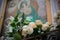 Horizontal view of a votive catholic icon decorated with flowers