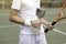 Horizontal view of young unrecognizable amateur tennis player holding an award winning cup on a tennis court