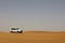 Horizontal wide shot of a car SUV traveling on a desert in Dubai, UAE
