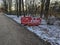 Horizontally framed, the image showcases red construction barriers amidst the serene city park