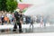 HORKI, BELARUS - JULY 25, 2018: Lifesaver of service rescue 112 pours water from a fire hose during a holiday in a park