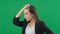 Horrible, stress, shock. Female portrait isolated at green screen background. Young emotional surprised woman clasping
