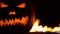 Horrible symbol of Halloween - Jack-o-lantern. Scary head of pumpkin in hell fire flames. Half of orange gourd on the