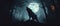 Horror angry werewolf howling at the moon in a forest with twisted trees Halloween background