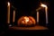 Horror Halloween concept. Close up view of scary dead Halloween pumpkin glowing at dark background. Rotten pumpkin head