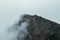 Horror mountain shadows. Dramatic fog among giant rocky mountains. Ghostly atmospheric view to big cliff. Low clouds and beautiful